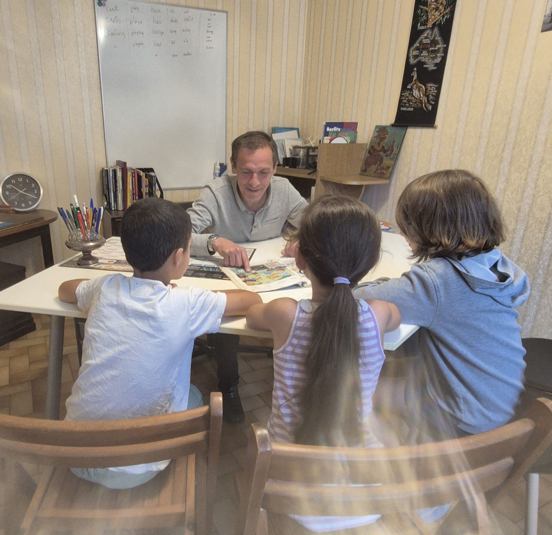Enseignant d'anglais fait son groupe grâce à un manuel pour capter l'attention et faire comprendre l'anglais aux enfants lors d'un cours d'éveil à Villefranche-de-Lauragais chez Enjoy English