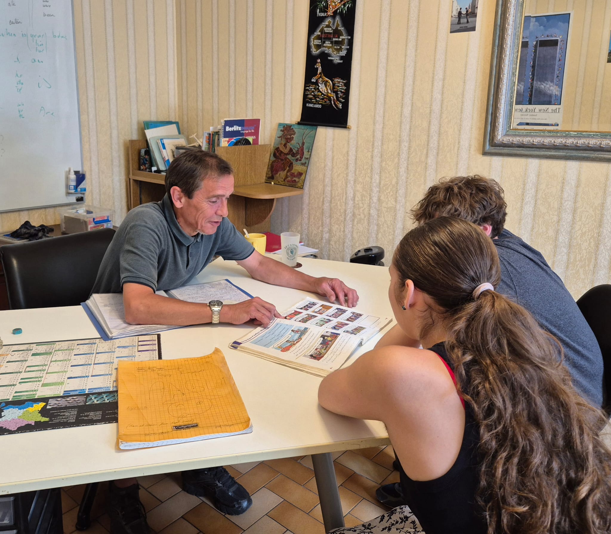 Professeur d'anglais expliquant en exercice à deux étudiants à Villefranche-de-Lauragais près de Toulouse, dans les locaux d'enjoy english